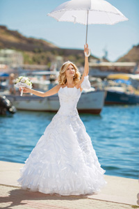 Heiraten am Meer - eine Braut im Brautkleid im Hafen am Strand